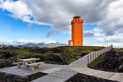 Orange lighthouse Skalasnagaviti or Svoertuloft with wooden boardwalk