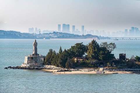 Buddha statue on an island with Xiamen in the background