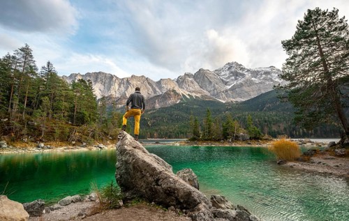 Young man standing on a rock on the shore