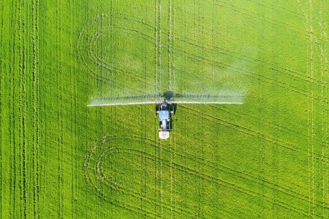 Tractor spraying fungicide onto the rice fields