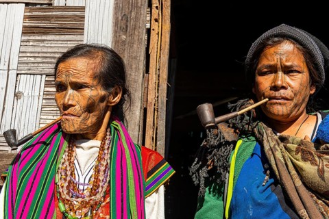 Chin women with spiderweb tattoo smoking a pipe