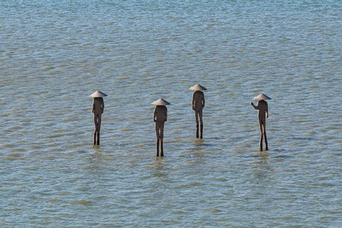 People statues standing in the ocean