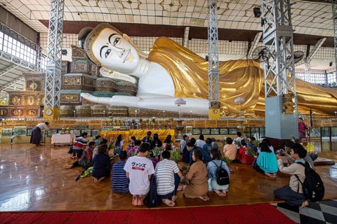 Pilgrims praying before the reclining buddha