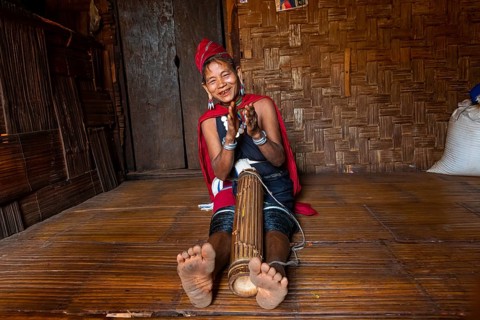 Old Kayah woman playing local instrument