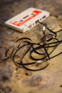 Old broken music cassette on brown background