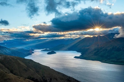 Last rays of sun shining through cloudy sky