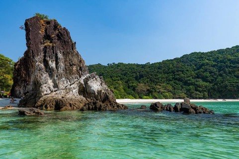 Rocky cliff on a untouched white sand beach on Smart island