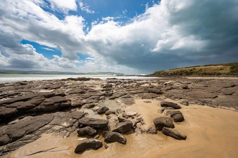 Sandy beach beach and rocks in Curio Bay