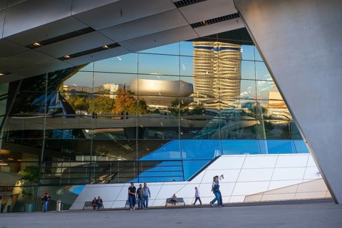 BMW Tower and BMW Museum reflected in the BMW Welt customer experience and exhibition facility building