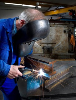 Worker in an industrial hall during oxyacetylene welding