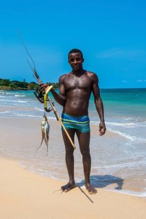 Man with fresh fished squid on the beach Praia dos Governadores