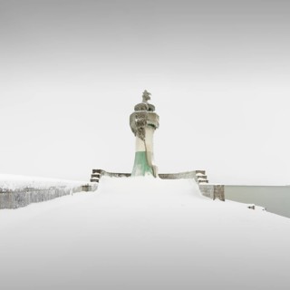 Iced quay wall and lighthouse in the harbour of Sassnitz on the island of Ruegen