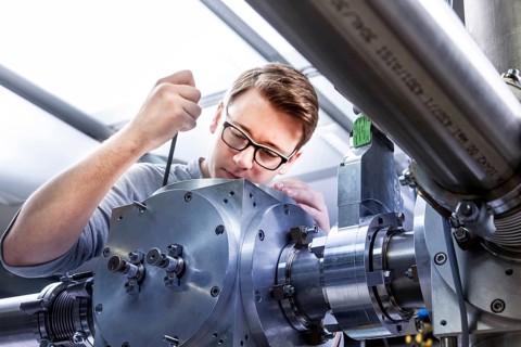 PhD student during his research work adjusting his experimental setup