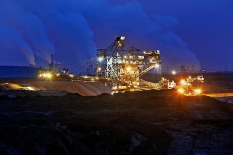 Opencast lignite mine with stacker and power plants in the evening