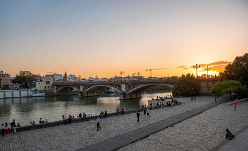 Waterfront Muelle de la sal at the river Rio Guadalquivir with bridge Puente de Triana