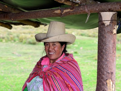 Indigenous woman with typical hat smiling at the camera