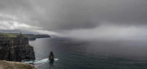 Thunderclouds and rain showers over cliff and Atlantic Ocean