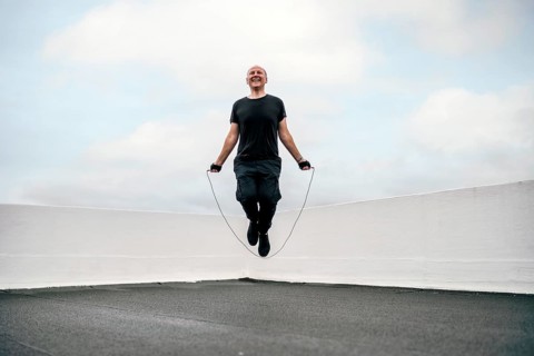 A man exercising on the rooftop using a jumping rope during lockdown