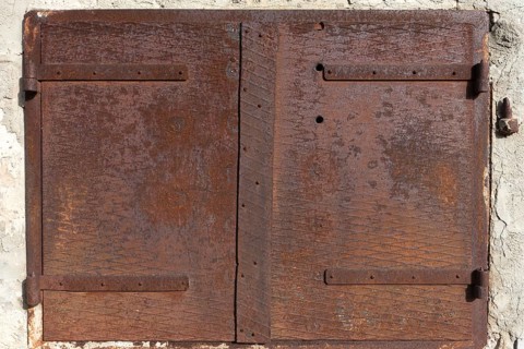 Rusty iron hatch on a house