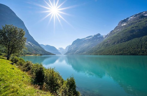 Sun shining at lake Lovatnet and mountains