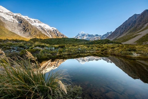 Reflection in small mountain lake at sunrise