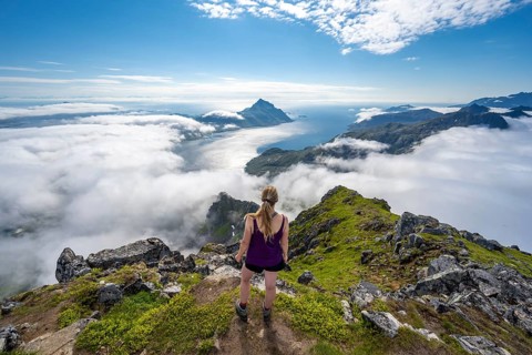 Hiker looking over mountain landscape in clouds