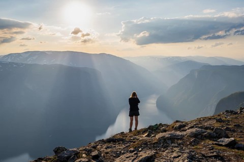 Hiker taking pictures of fjord landscape
