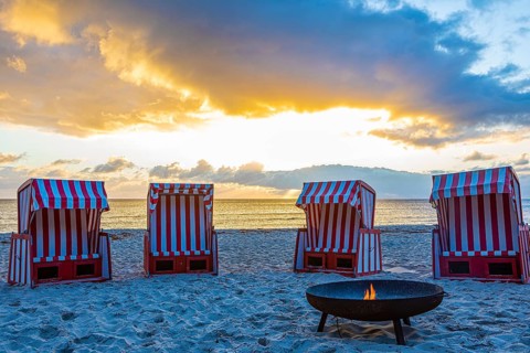 Beach chairs and fire bowl at sunrise at the big beach of Thiessow