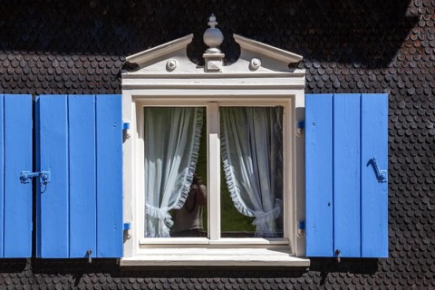 Window with blue shutters on an old farmhouse