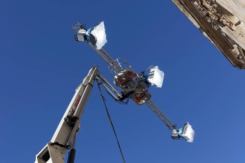 Three spotlights in front of a blue sky