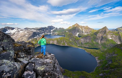 Young woman looking over mountain landscape with lake Tennesvatnet and Krokvatnet