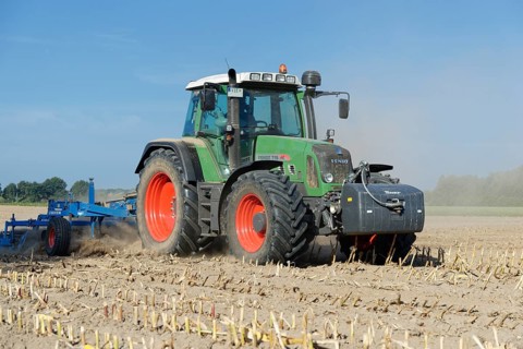 Farmer cultivating harvested maize field