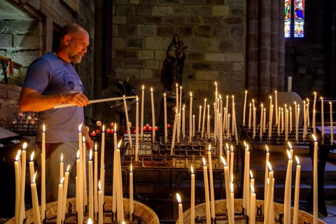 Man lighting a votive candle