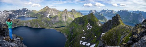 Young woman looking over mountain landscape with lake Tennesvatnet