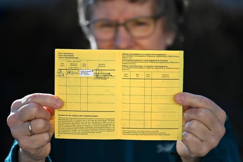 Woman proudly showing her vaccination certificate after being vaccinated with AstraZeneca against Covid-19