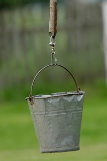 Dented metal bucket on wellstick