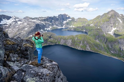 Young woman looking over mountain landscape with lake Tennesvatnet