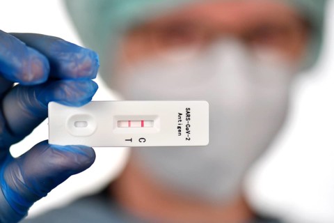 Medical staff shows positive antigen rapid test