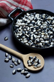 Dried bush beans in pot with cooking spoon