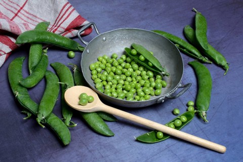 Green peas in pod and cooking spoon