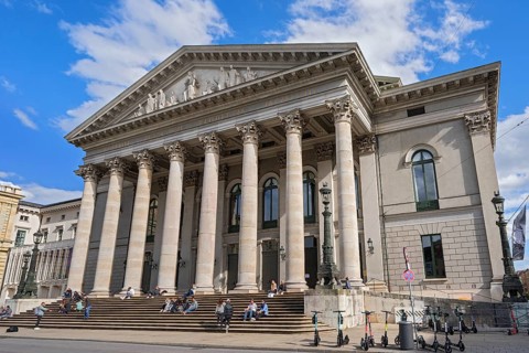 People sunbathing on the stairs in front of the opera