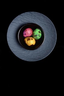 Coloured quail eggs in small bowls