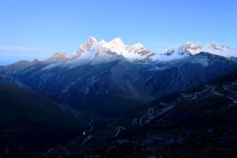 Winding mountain road and massif of Nevado Huandoy at dawn