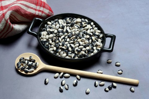 Dried bush beans in pot with cooking spoon