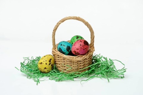 Coloured quail eggs in baskets