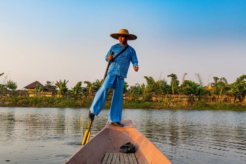 Fisherman at Inle Lake with traditional Intha conical net at sunset