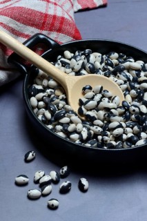 Dried bush beans in pot with cooking spoon