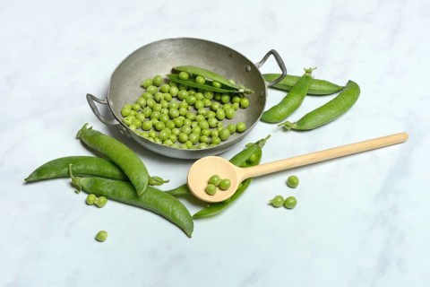 Green peas in pod and cooking spoon