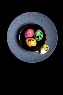 Coloured quail eggs in small bowls