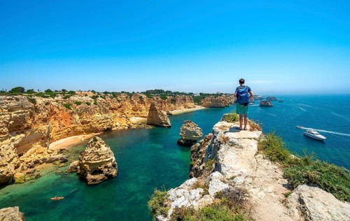 Young man standing on rocks on cliff
